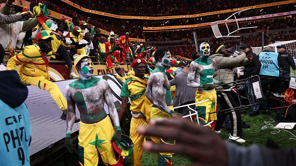 Fans scuffle with security personnel as they storm the field after a penalty decision against Senegal during the Africa Cup of Nations 